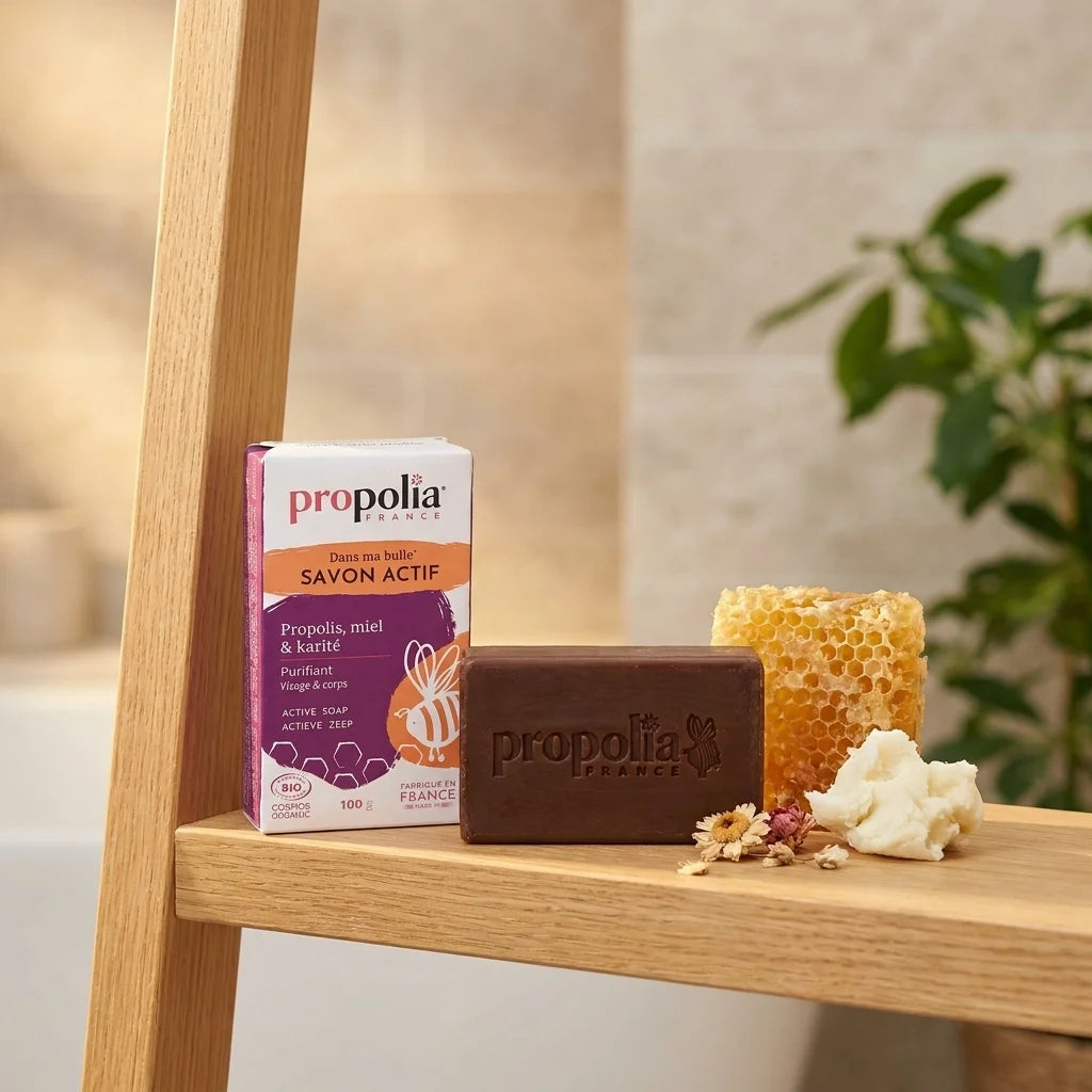 Savon bio Propolia à la propolis, miel et karité sur étagère avec miel et beurre de karité