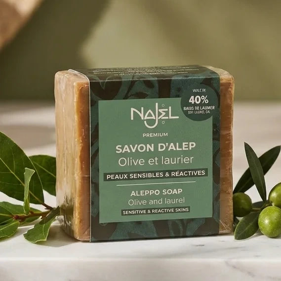 Savon d'Alep 40% HBL Najel avec feuilles de laurier sur marbre, esthétique bien-être