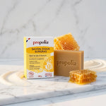Savon doux surgras bio Propolia avec miel et emballage jaune sur marbre blanc