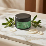 Savon noir Najel à l'huile d'argan en pot sur marbre avec branches d'argan
