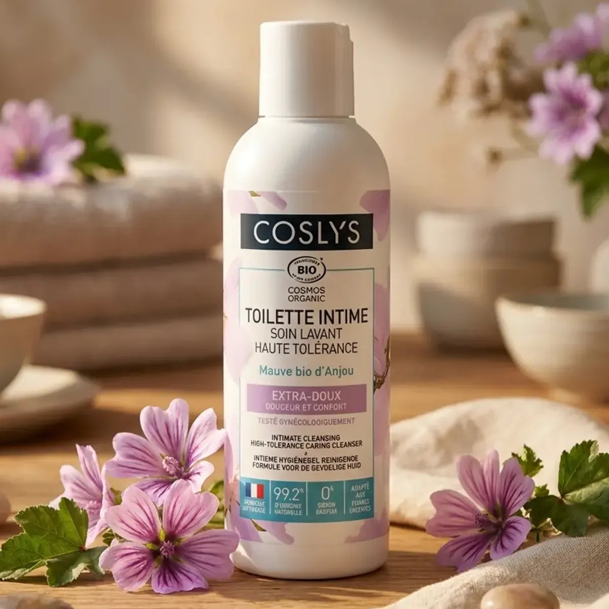 Soin lavant toilette intime Coslys bio 100ml avec fleurs de mauve sur fond spa