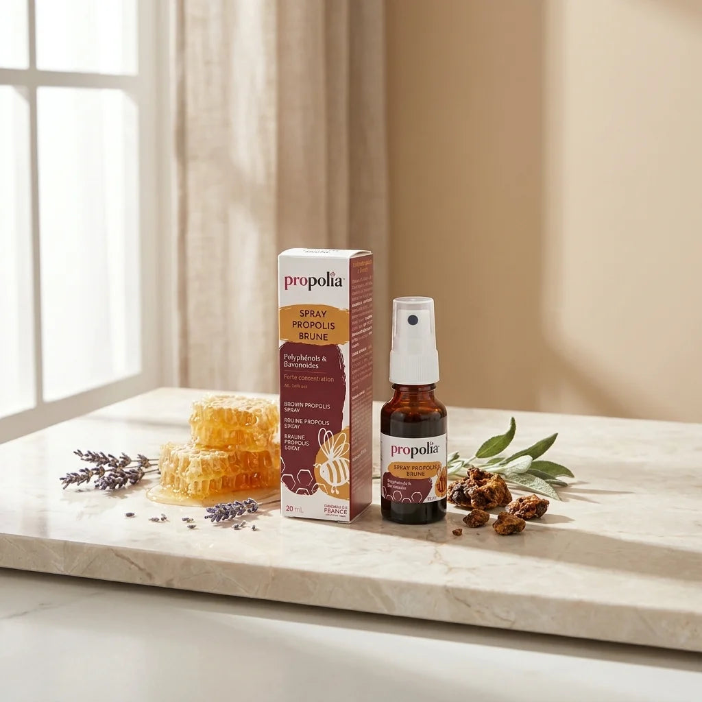 Spray de propolis brune Propolia sur marbre blanc avec rayon de miel et herbes séchées