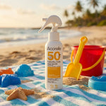 Spray solaire Acorelle SPF50 bio pour enfants sur serviette de plage avec jouets colorés
