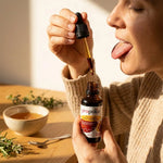 Teinture mère Propolis brune Propolia, femme appliquant les gouttes sur la langue