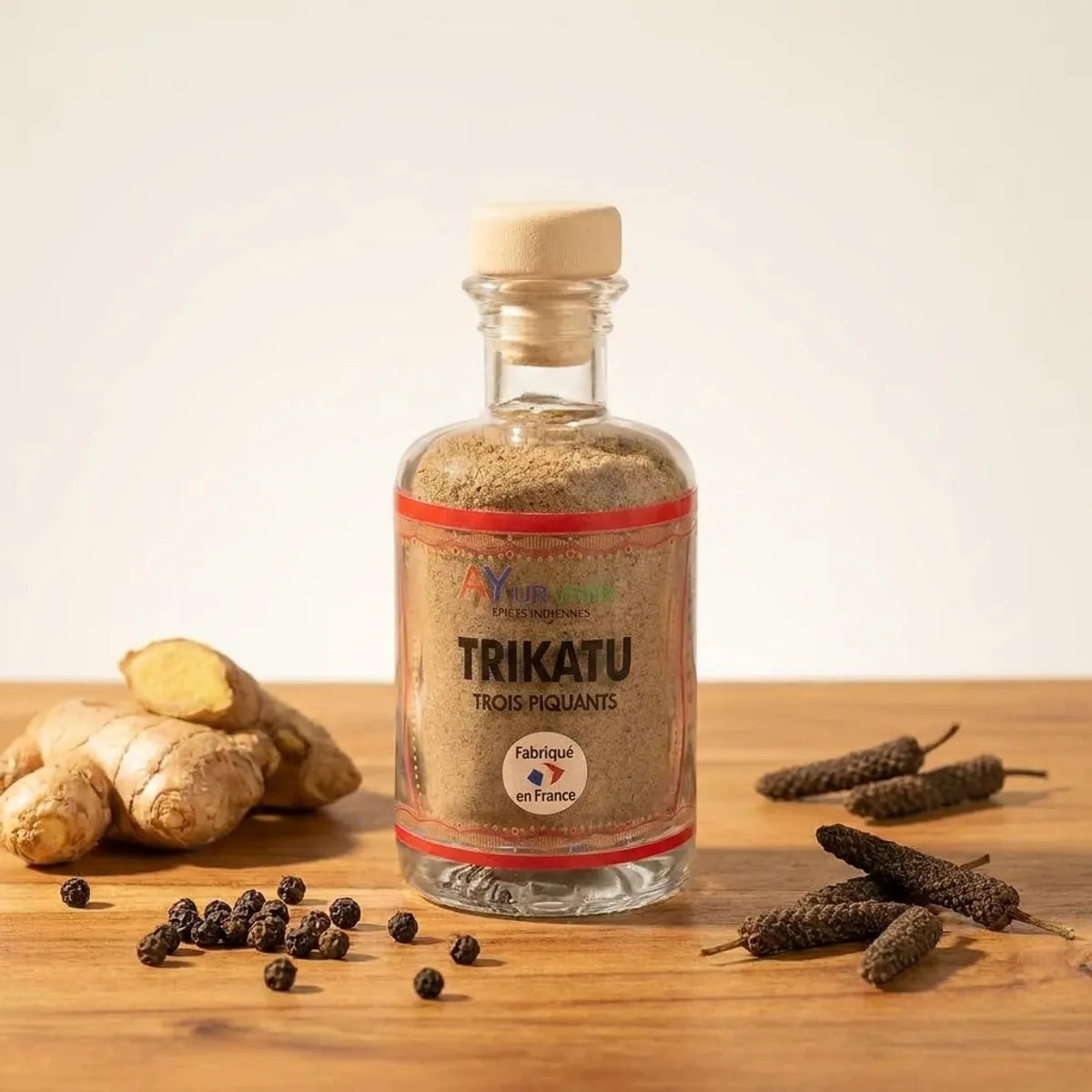 Ayurvana Trikatu - flacon verre avec gingembre frais, poivre noir et long poivre sur bois