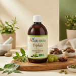Bouteille Ayurvana Triphala bio 500ml sur surface bois avec herbes et épices ayurvédiques