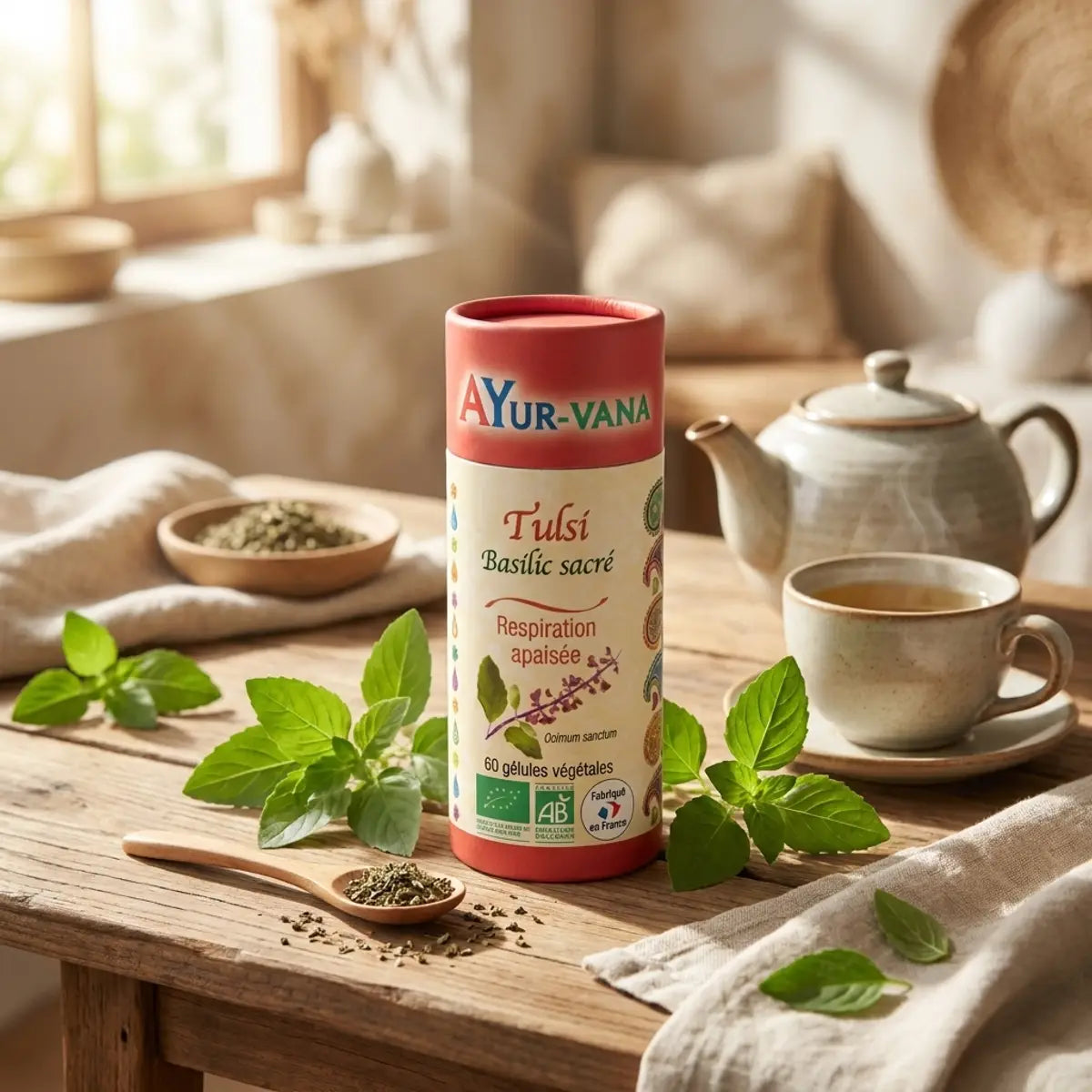 Gélules Tulsi bio Ayur-Vana avec feuilles fraîches et packaging rouge crème sur surface bois
