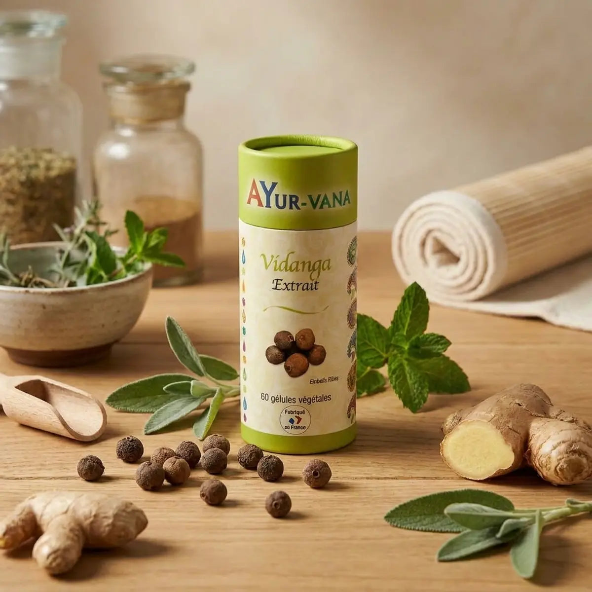 Gélules Vidanga Embelia ribes Ayur-vana sur bureau wellness avec herbes et gingembre
