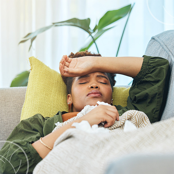 Photo d'une personne malade allongée dans son canapé