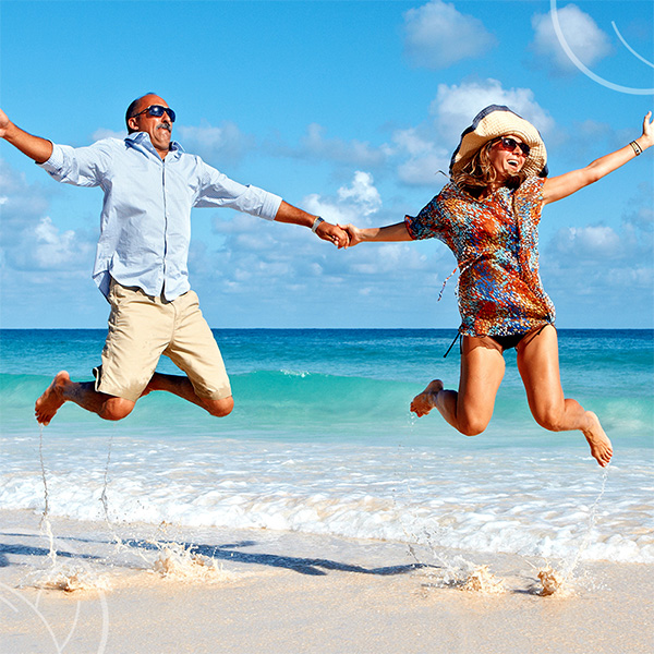 Photo d'un couple sautant sur la plage plein d'énergie
