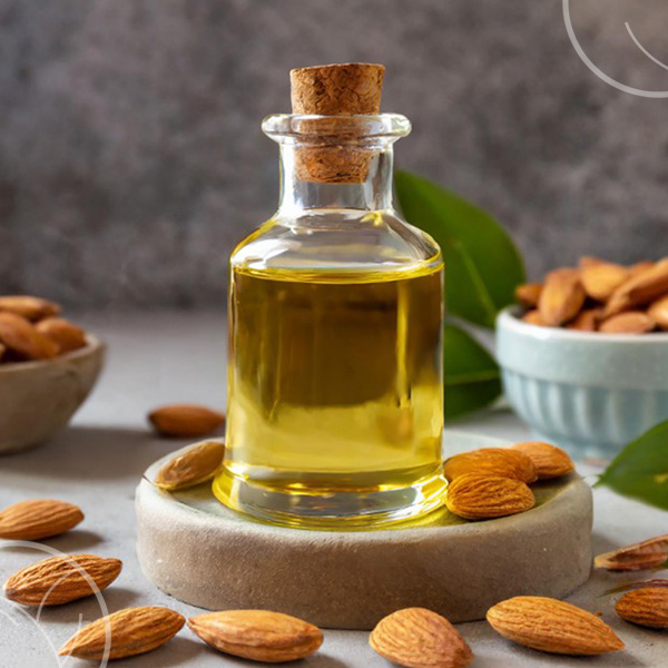 Photo d'un flacon d'huile d'amande douce avec des amandes autour du flacon