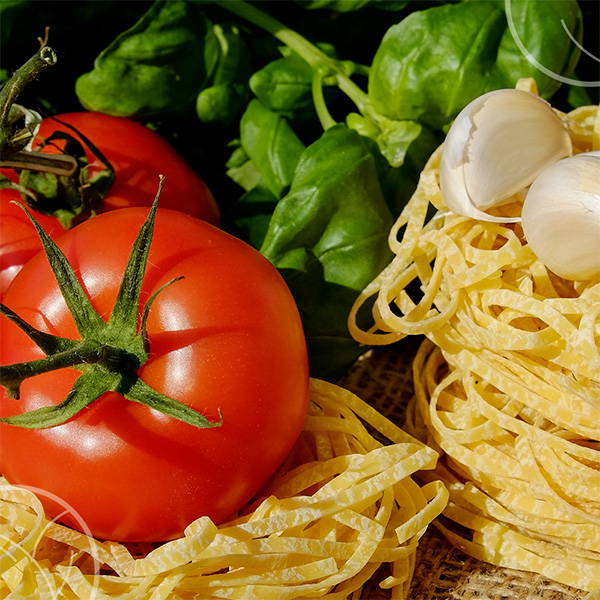 Photo d'ingrédients pour une salade à l'italienne : pâtes, basilic, tomates, ail