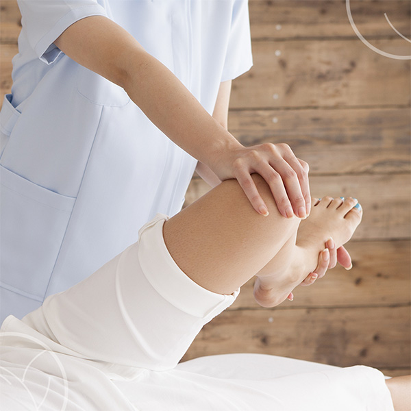 Photo d'une personne tenant la jambe d'une autre personne pour faire bouger ses articulations