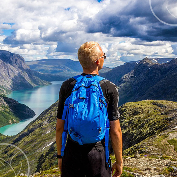 Photo d'un homme en haut d'une montagne et qui admire la vue