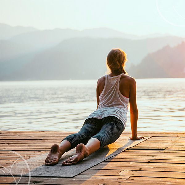 Photo d'une femme faisant du yoga en face d'une lac