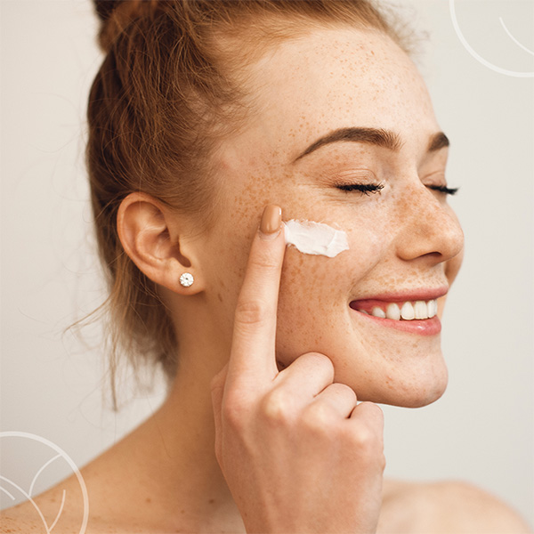 Femme qui se met de la crème sur le visage