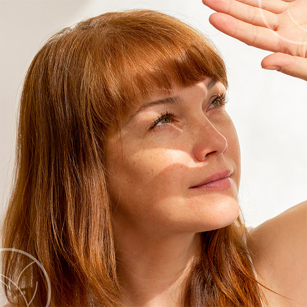 Une femme se cachant le visage du soleil avec sa main